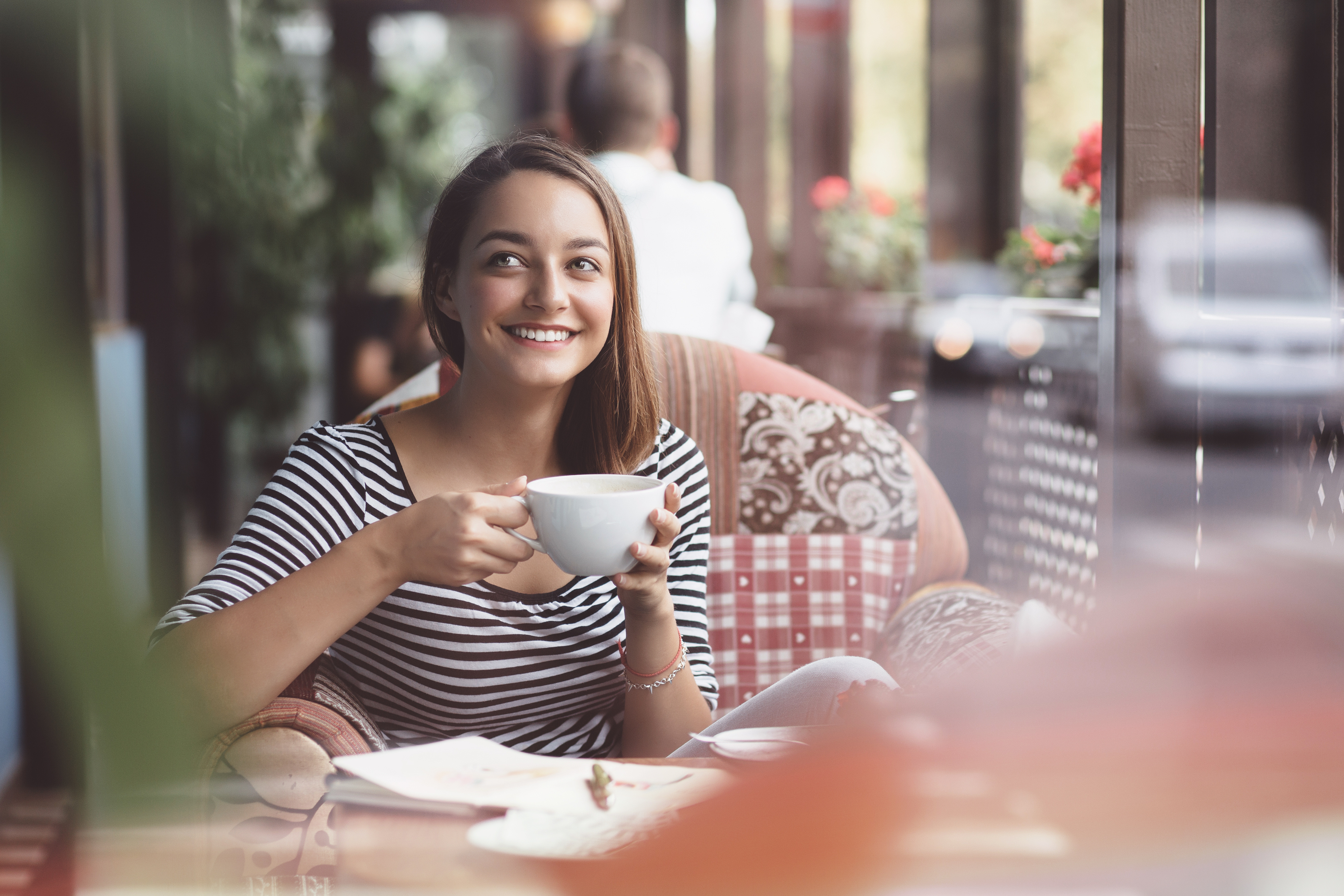 Glückliche Frau im Café mit Kaffeetasse