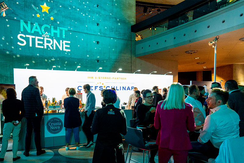 Gäste der Nacht der Sterne im Mercedes-Benz-Museum in Stuttgart vor einer der Live-Stationen, an denen Essen ausgegeben wird