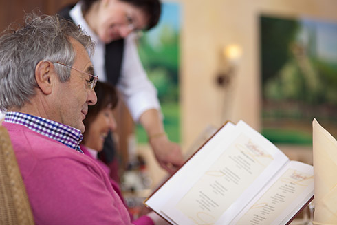 Gast schaut sich im Restaurant die Speisekarte an