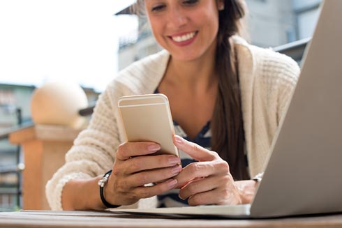 Frau mit Smartphone schaut sich die App 