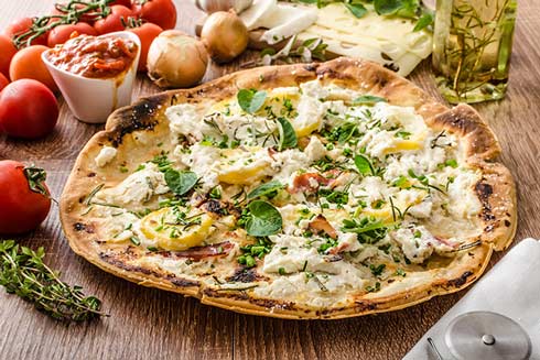 Köstlich: eine Pizza bianca mit Ricotta, Kräutern und Schinken