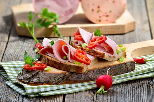 Reichlich belegte Scheibe Brot mit Schinken, Salat und Paprika