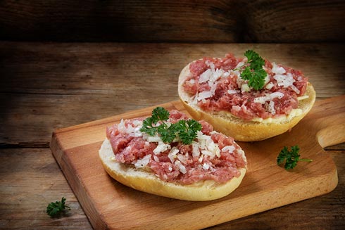 Ein Brötchen belegt mit Mett und Zwiebeln gehört in der Gemeinschaftsverpflegung zu den Risiko-Lebensmitteln