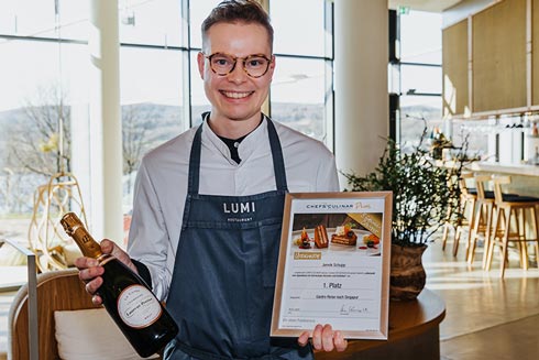 Genuss-Contest-Gewinner Jannik Schupp mit CHEFS CULINAR Urkunde und einer Flasche Champagner