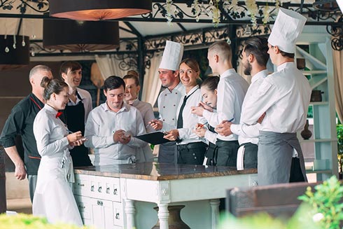 Teambesprechung unter Kellnern und Köchen
