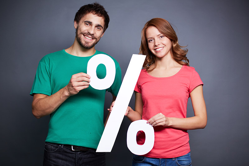 Ein Mann und eine Frau halten ein Prozente-Zeichen