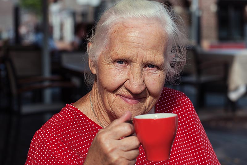 Ältere Frau genießt eine Tasse Tee – denn genügend zu trinken, ist gerade im Alter wichtig