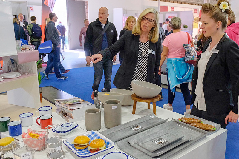Besucher lassen sich auf der CHEFS CULINAR Messe in Berlin zum Thema Geschirr beraten
