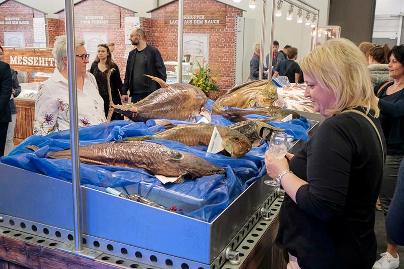 Besucher der CHEFS CULINAR Messe in Berlin schauen sich die ausgestellten Fische an