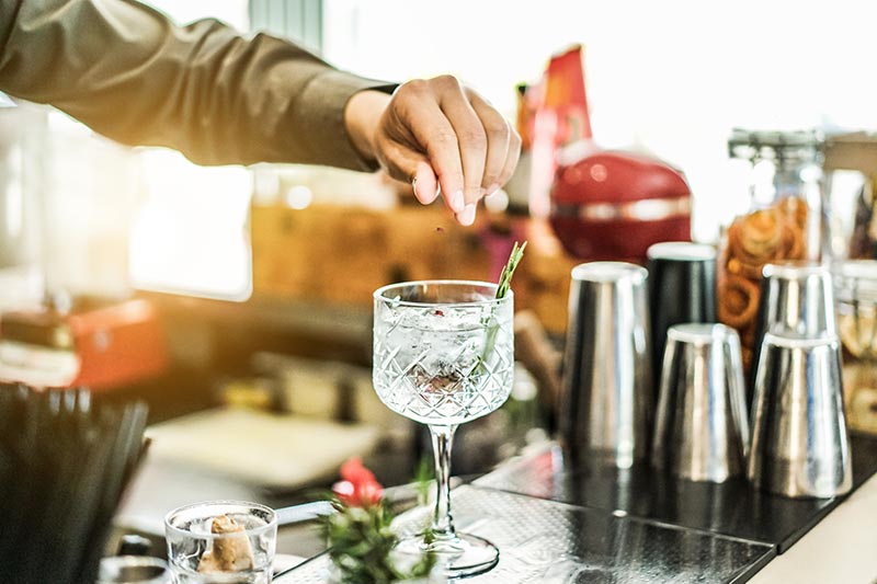 Bar-Keeper gibt Eis in ein Cocktail-Glas – die aktuellen Cocktail-Trends gibt's bei CHEFS CULINAR