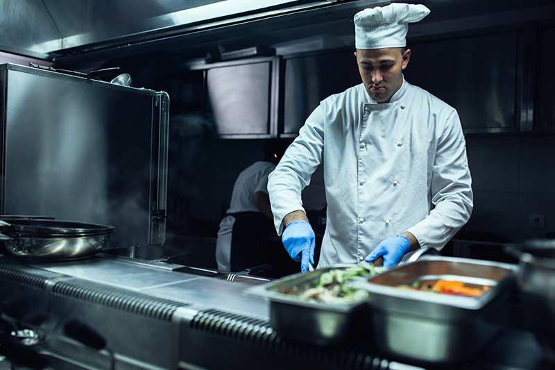 Koch in der Großküche bereitet Essen zu