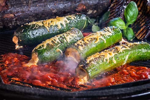 Gegrillte Zucchinibratwurst mit Mozzarella und Tomate gefüllt in Curry-Sauce