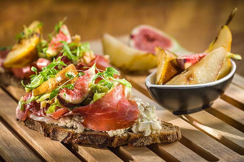 Roggenbrotstulle mit Schinkenspeck, gegrillter Birne und Spitzkohl