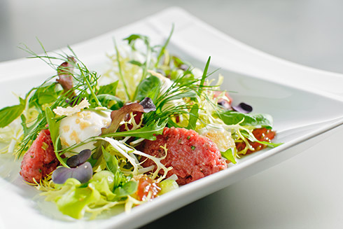 Beef Tatar mit Bierschaum im Salat-Kräuter-Feld