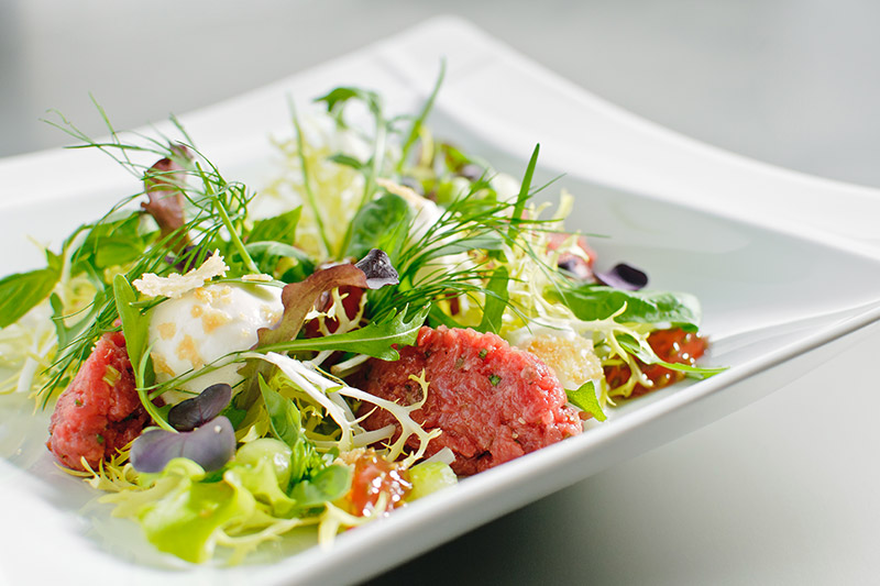 Beef Tatar mit Bierschaum im Salat-Kräuter-Feld