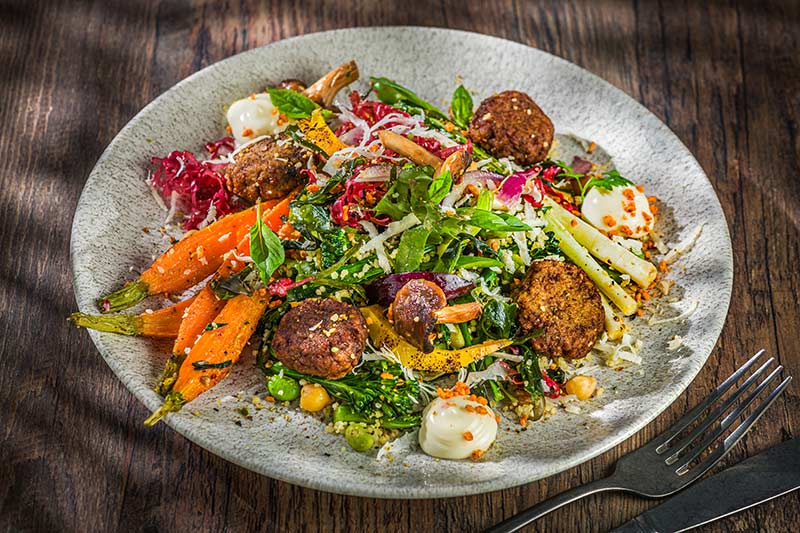 Vegane Frikadelle an warmem Algen-Gemüse-Salat, Mayo und Bacon-Bits