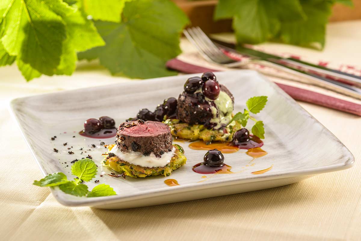 Rosa gebratenes Hirschfilet im Kartoffel-Lauchmantel auf Blaubeeren ...