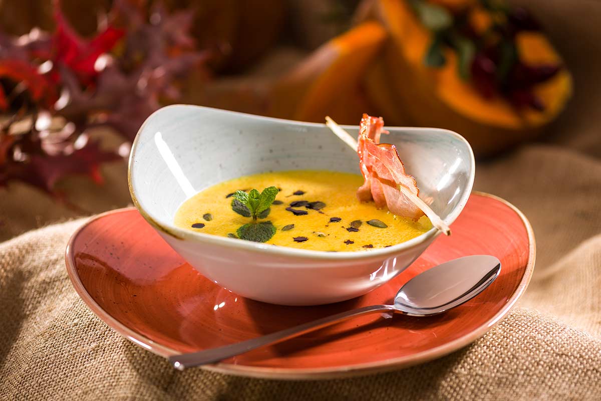 Kürbis-Cremesuppe mit gerösteten Kürbiskernen, Minze und gegrilltem ...